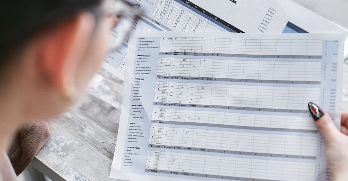 An accounts desk with a laptop showing a bank reconciliation screen, paper receipts and a calculator.